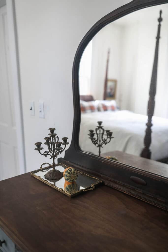 antique dresser with a vintage mirrored draw with a guard and candelabra