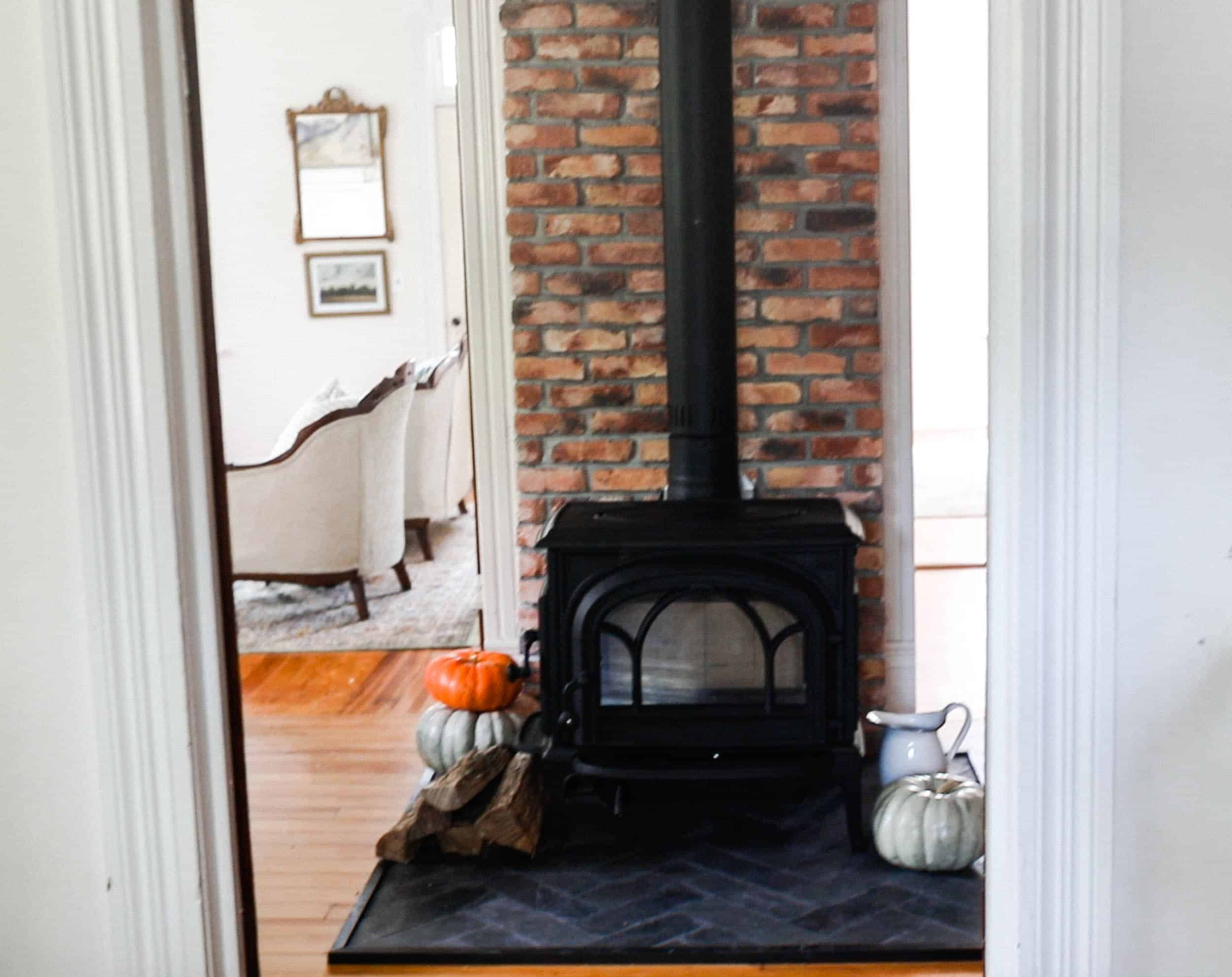 wood stove with a brick chimney and diy hearth pad with black slate