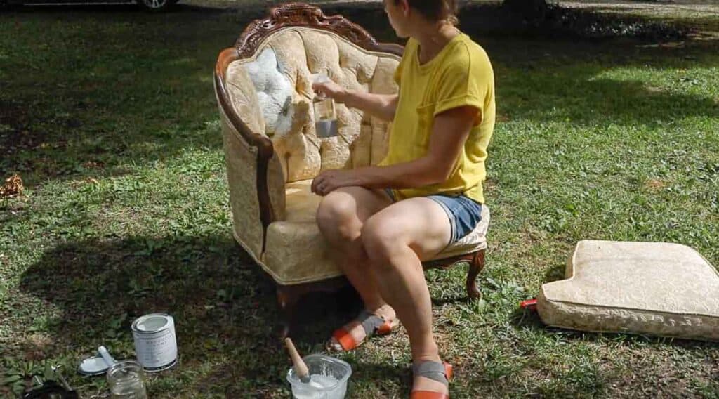 women wearing yellow shirt spraying chalk painted chair with water