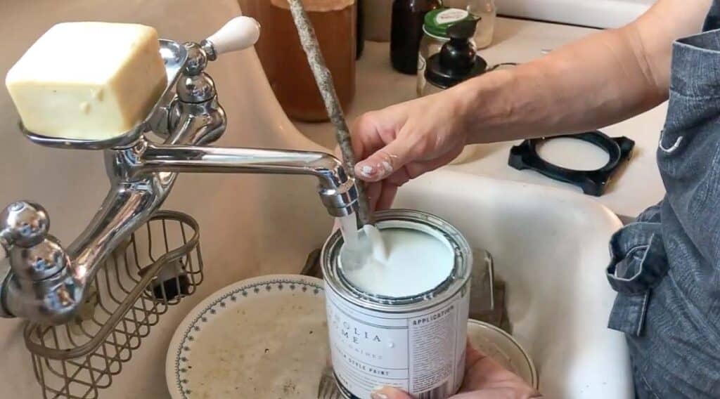 adding water to chalk paint in a farmhouse sink