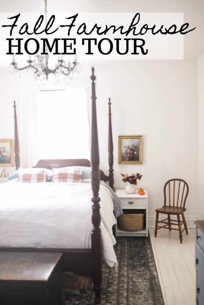 victorian farmhouse bedroom with orange plaid pillows on top a white linen duvet. A night stand to the right has dried fall florals and pumpkins