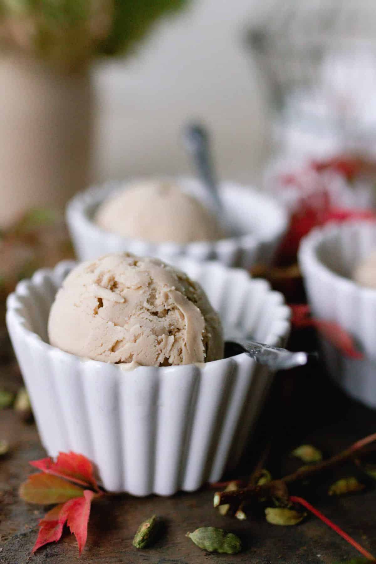 Small white bowls with a scoop of chai ice cream in them.