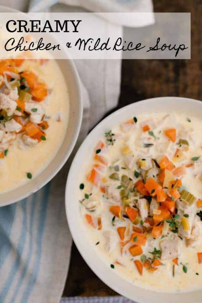 two bowls of creamy chicken and wild rice soup on a blue and cream stripped towel