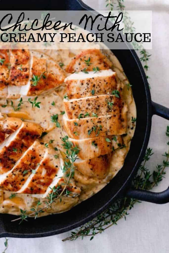 seared chicken breasts in a creamy peach sauce topped with herbs in a cast iron skillet