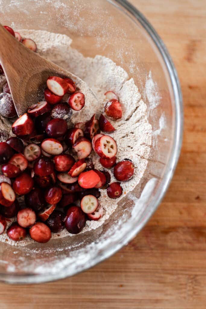 sliced cranberries in a glass bowl with remaining bread ingredients