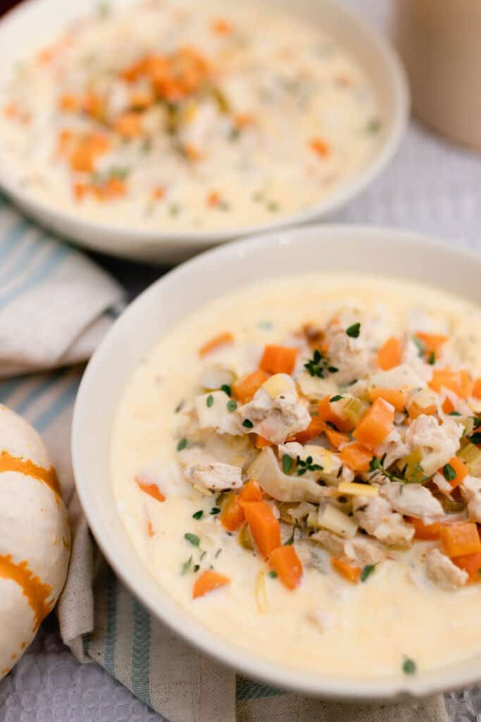 close up picture of two bowls of chicken and wild rice soup packed with veggies