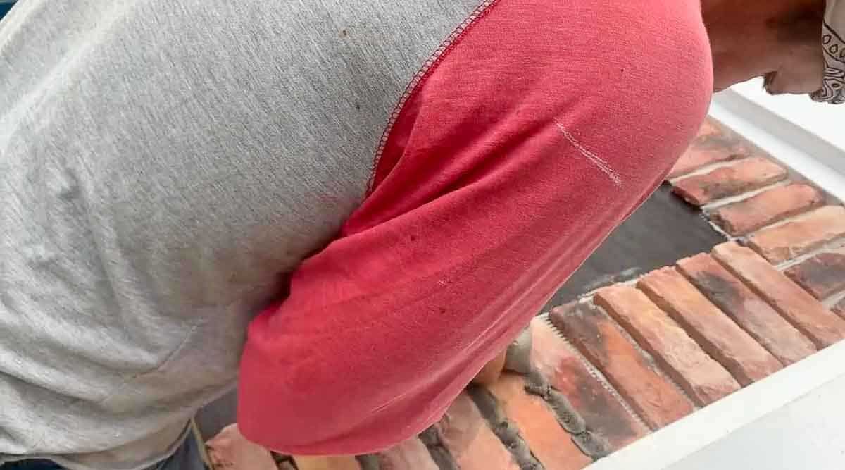 man adding mortar with a ziplock bag squeezing between each brick