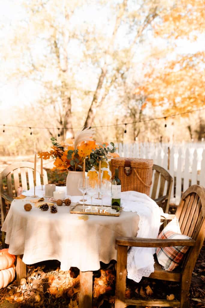 fall table scape outside next to a white picket fence.