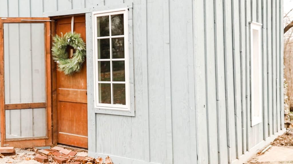 faux greenery christmas wreath on a antique cottage door