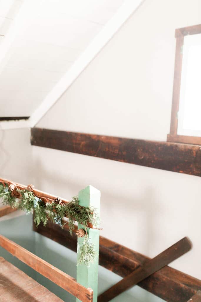 garland hung on a green and wood bannister 