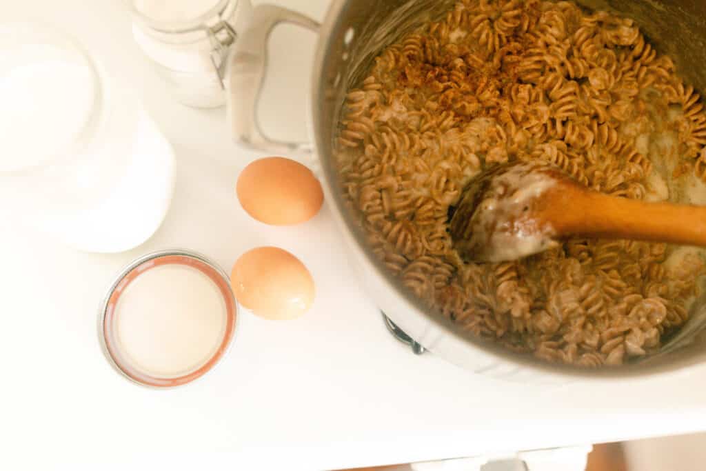 Macaroni and cheese in a pot with eggs to the left