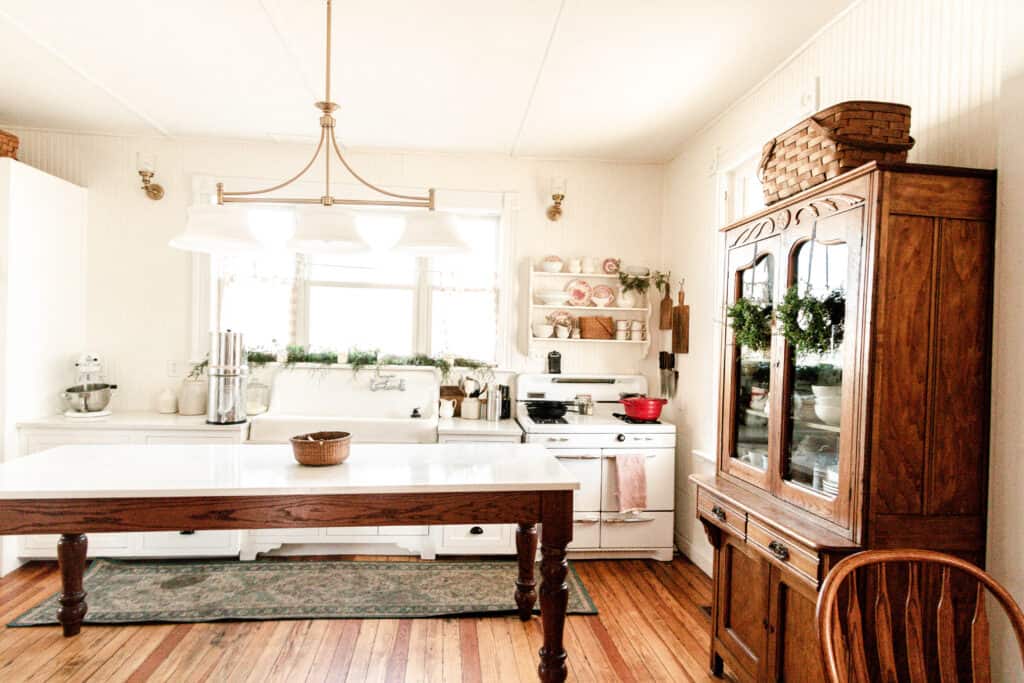 farmhouse kitchen decorated for Christmas with greenery and pops of red