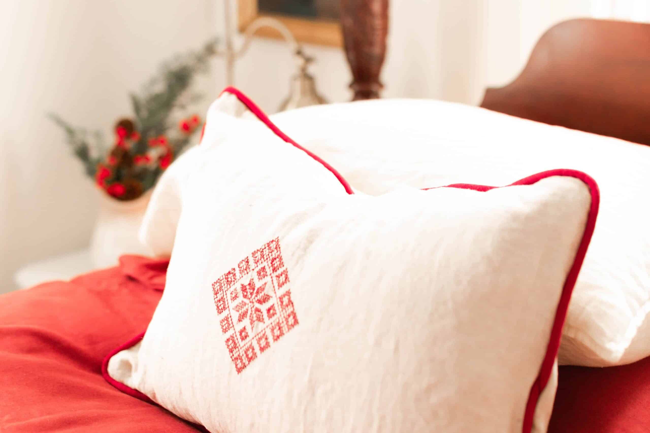 beautiful white an red pillow cases on a victorian style vintage bed with red and white linens