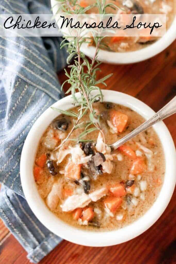 overhead photo of chicken Marsala Soup in two white bowls with a fresh spring of rosemary on top