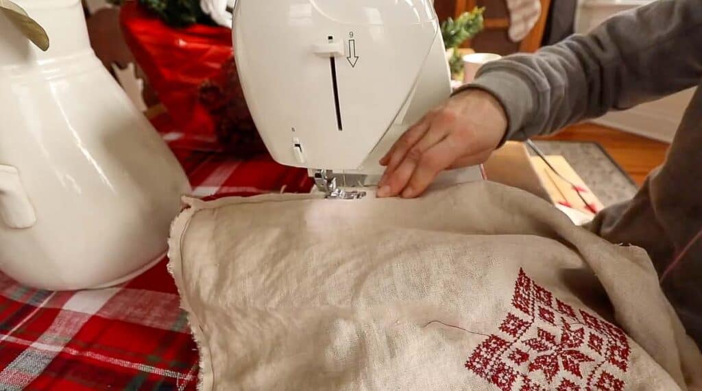 sewing a DIY Christmas pillow together at a sewing machine