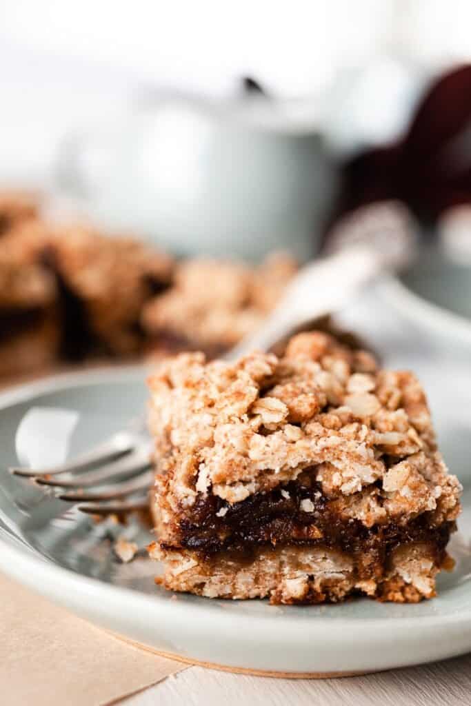 healthy date bar with oats on a soft green plate with a fork