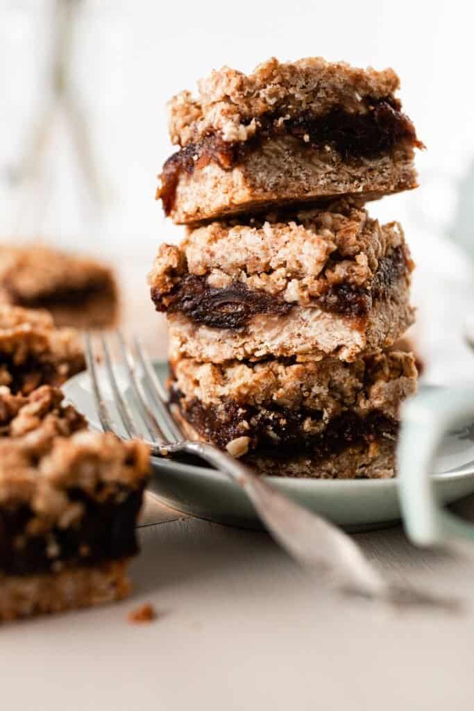 oat date bars stacked on a light green plate with a fork