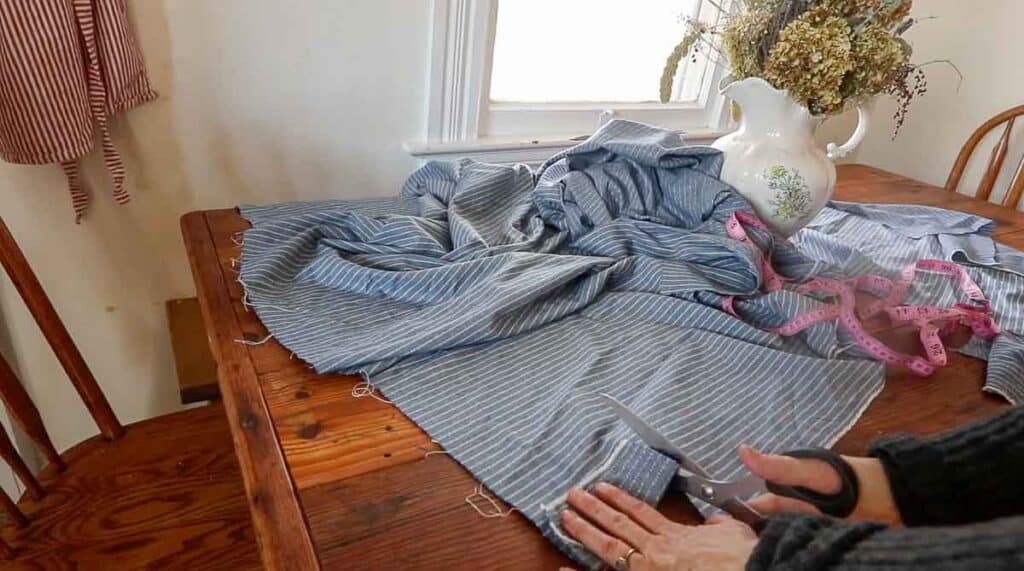 women cutting fabric out to create a half apron.