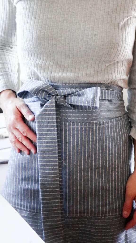 women wearing a blue and white stripped half apron with a bow tied in the front