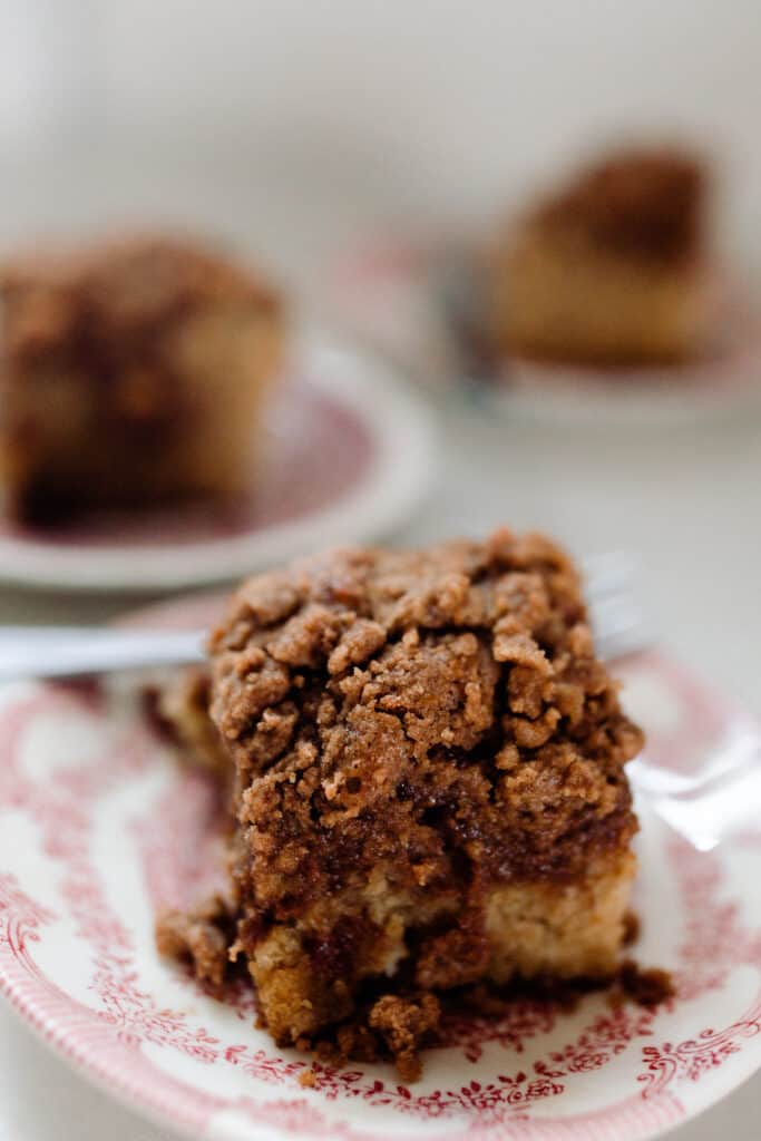 sourdough coffee cake with cinnamon crumble on a white and red vintage plates