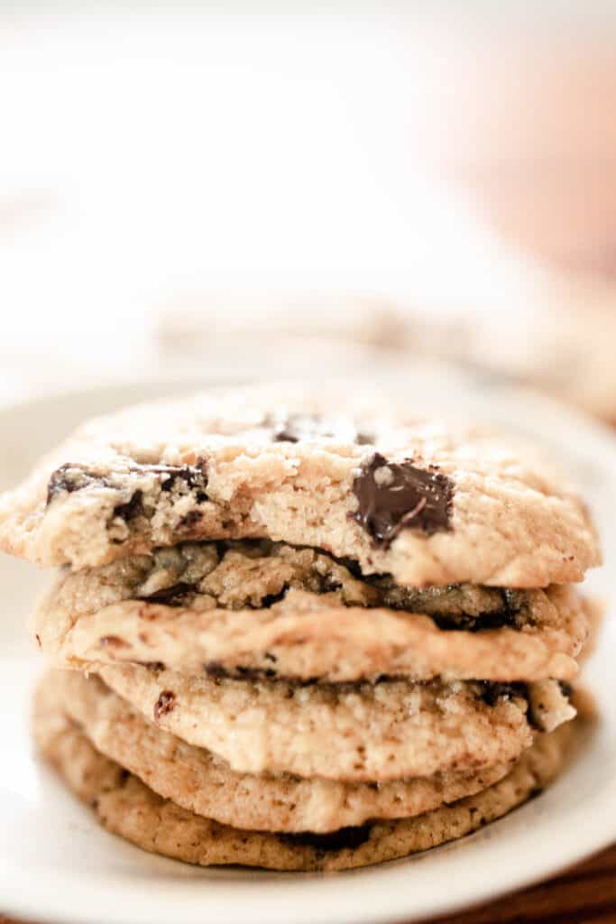 sourdough chocolate chip cookies stacked on a white plate