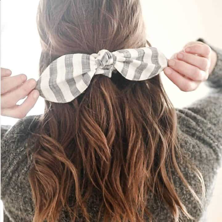 women with a gray sweater with her hair tied half up with a DIY scrunch bow