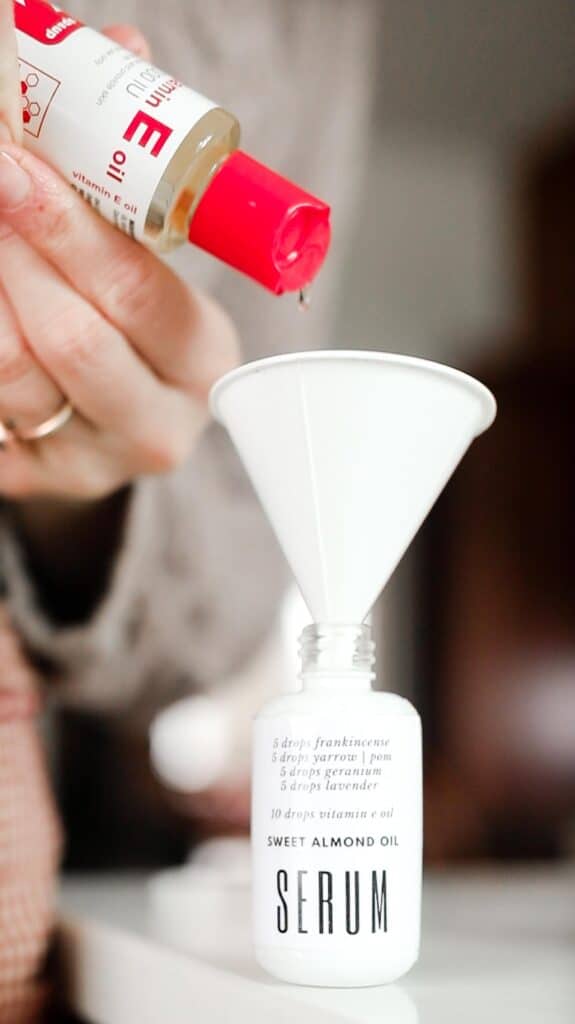 vitamin e oil being poured into a white bottle