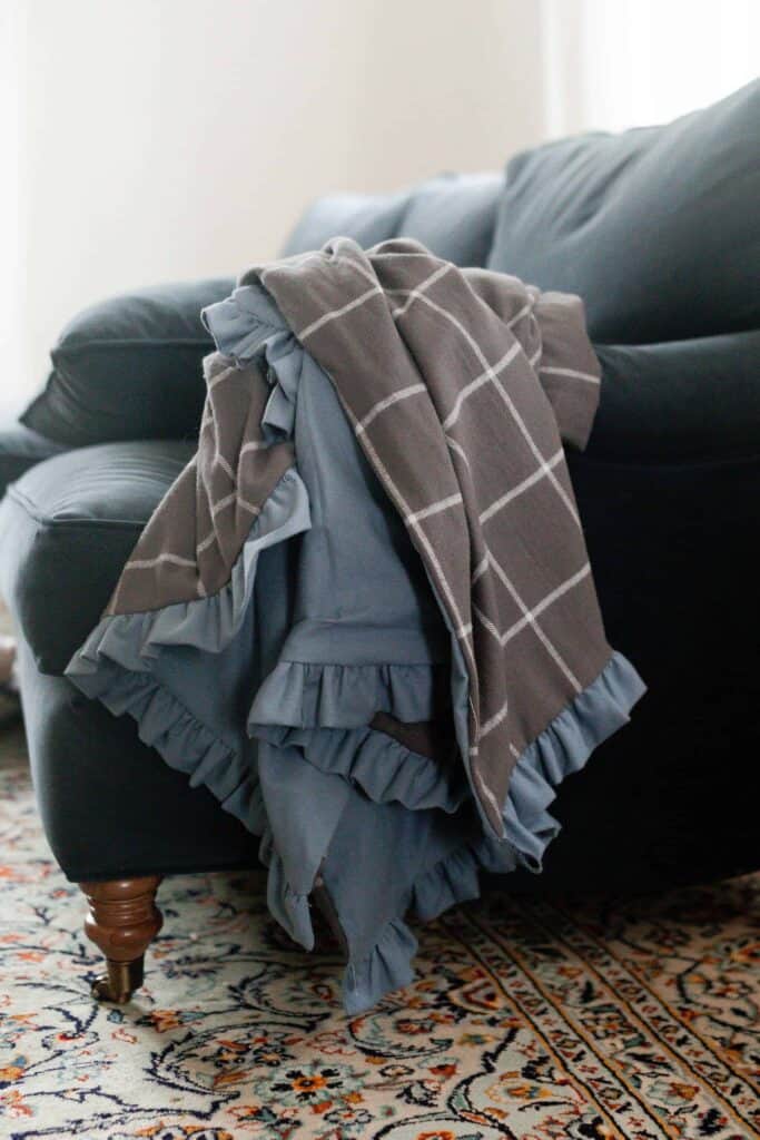 DIY flannel blanket with a ruffle on a blue couch