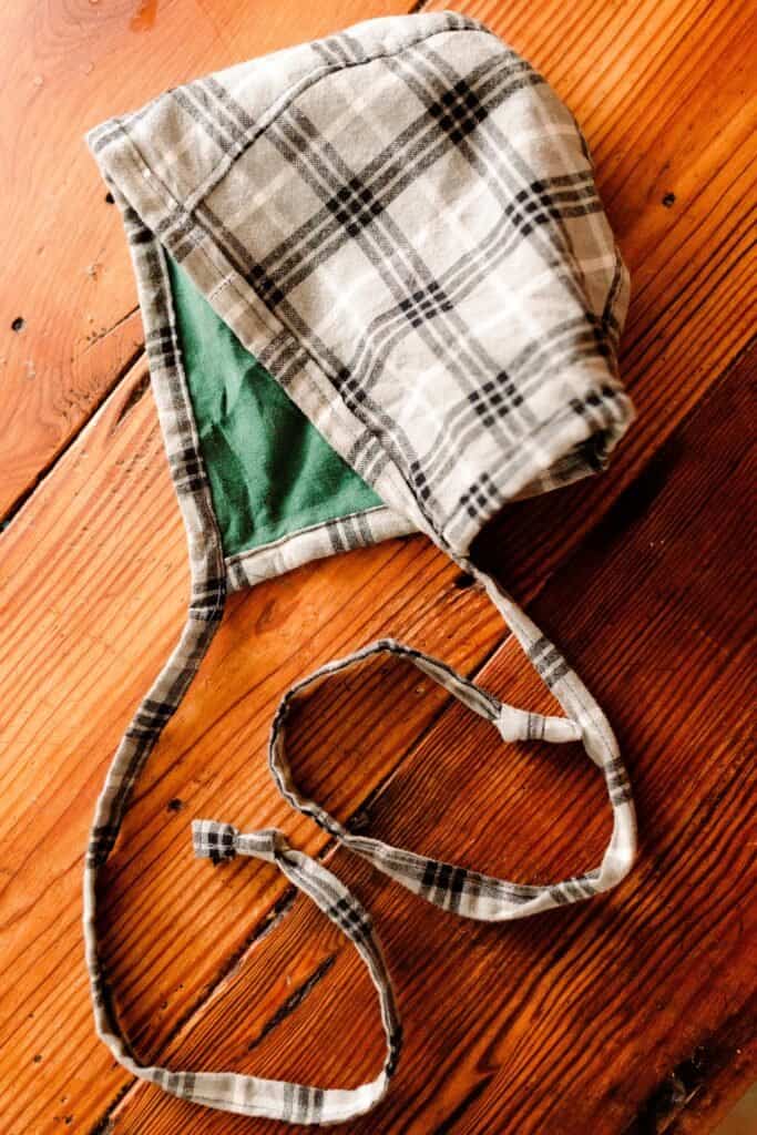 reversible baby bonnet on a wooden table