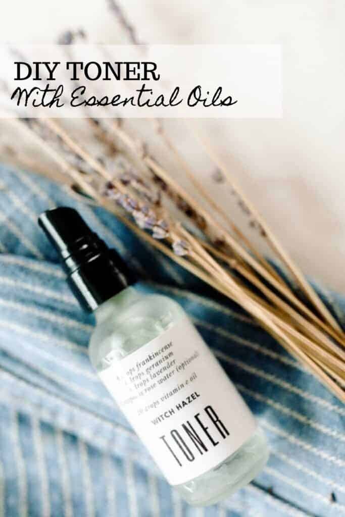 DIY Toner with essential oils in a frosted glass spray bottle on a blue and white stripped towel and dried lavender