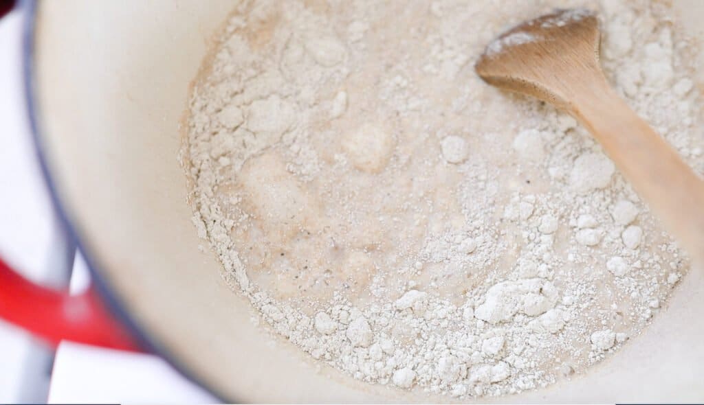 fresh coarsely milled einkorn flour and milk in a pot with a wooden spoon