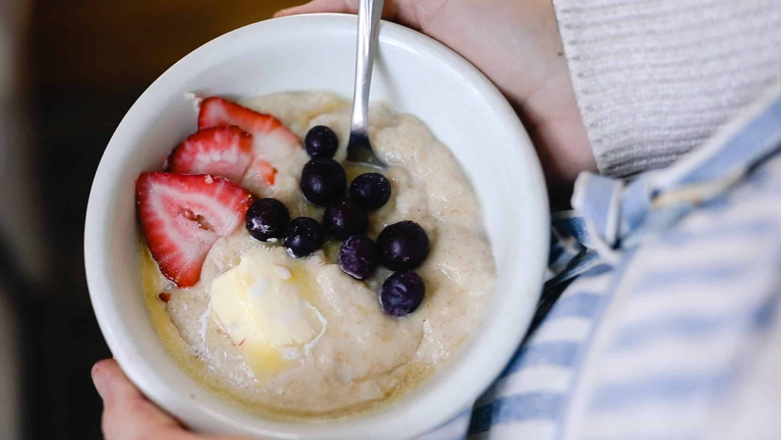 einkorn cream of wheat in a white bowl topped with blueberries and strawberries