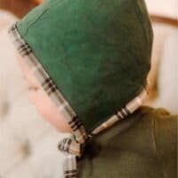 boy wearing a green homemade baby bonnet