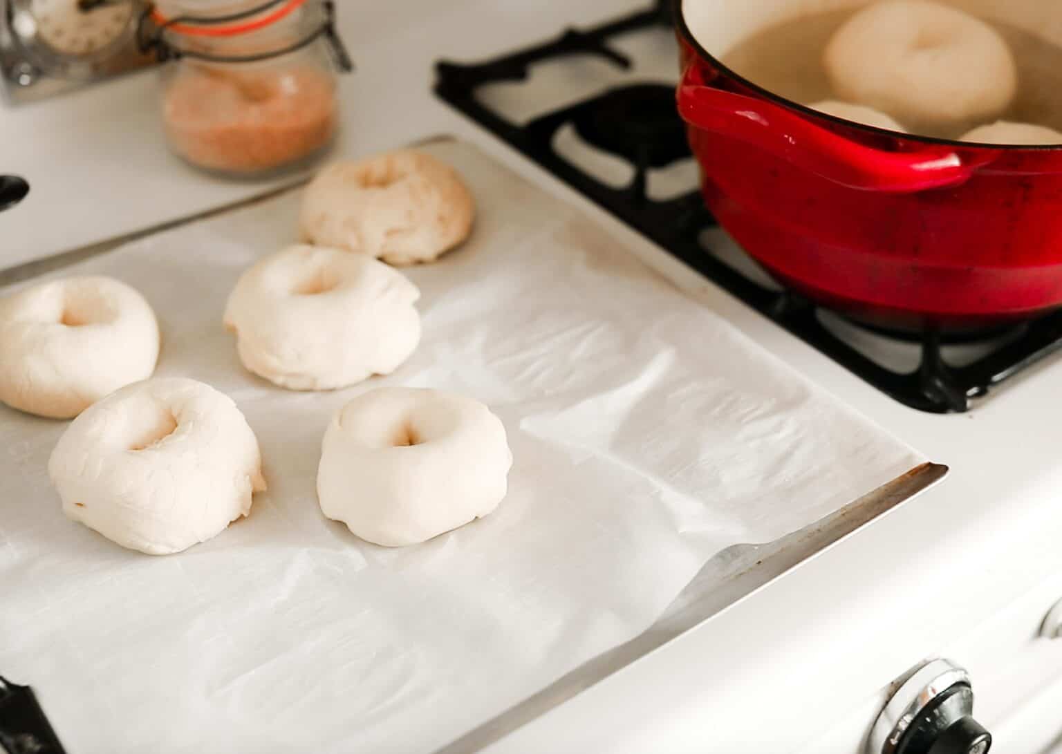 bagels being placed onto a baking sheet