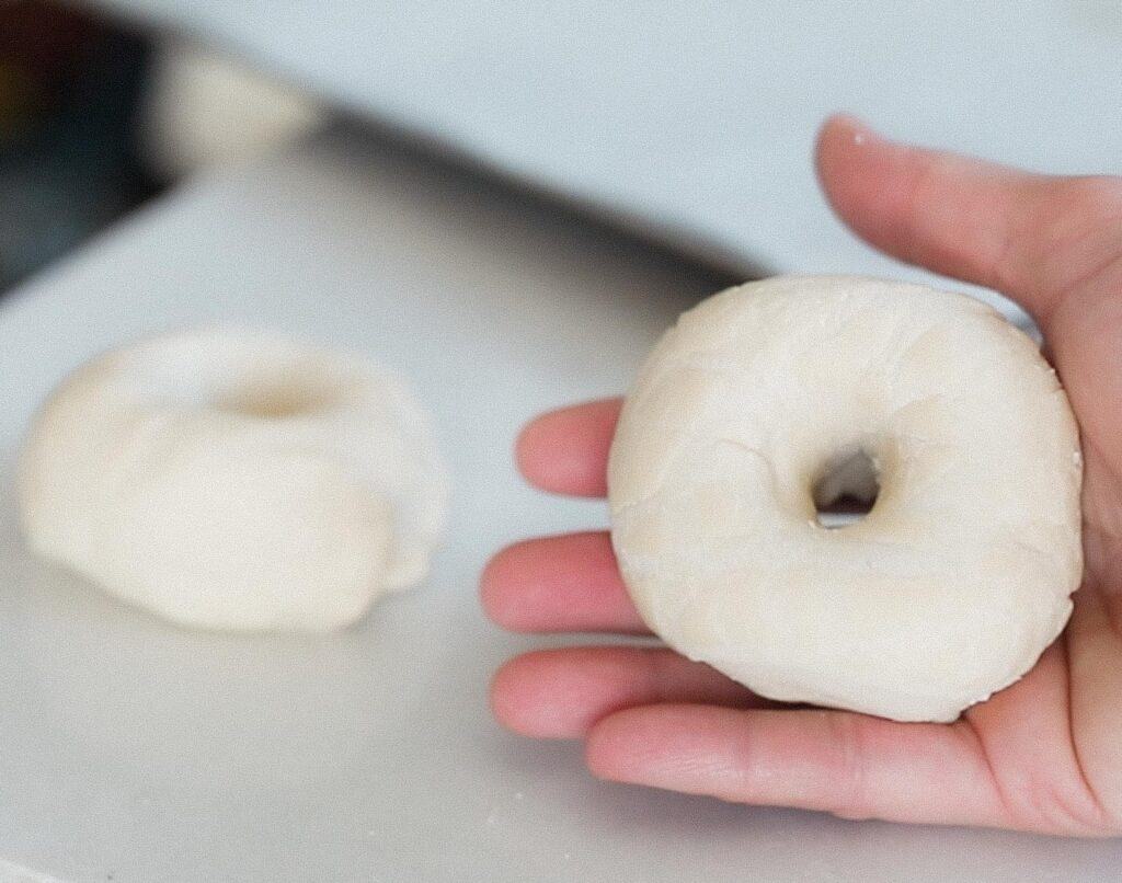 hand holding shaped sourdough bagel