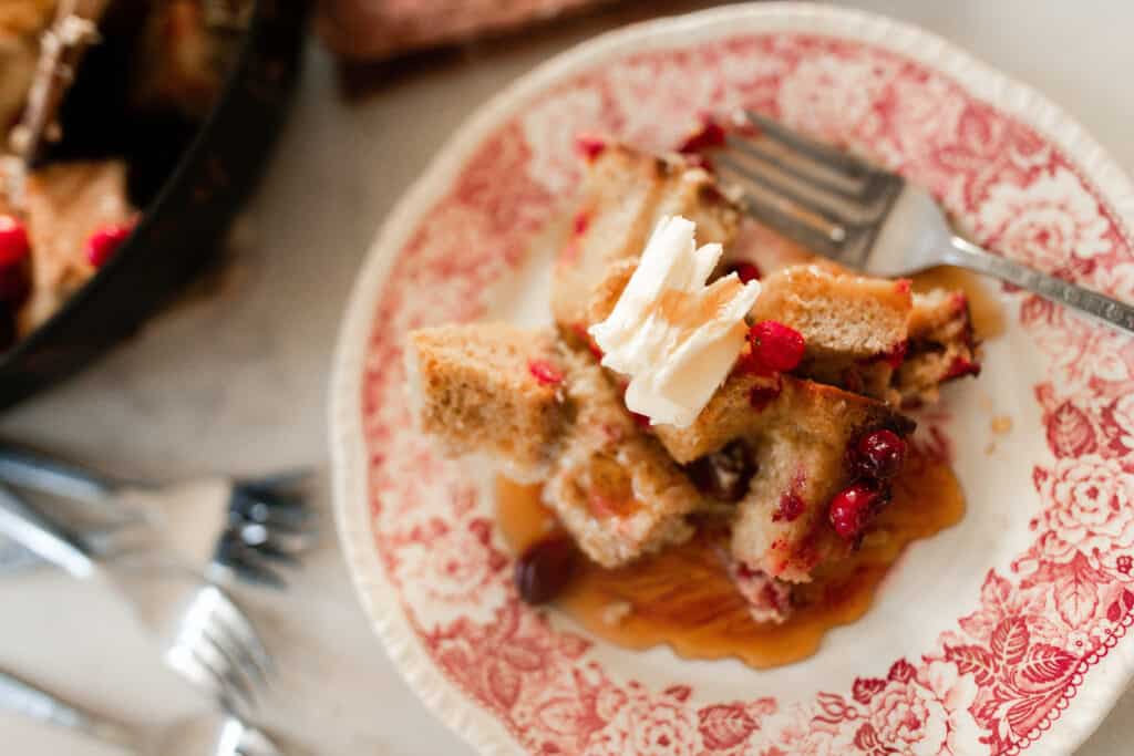 close up of sourdough French toast casserole on an red and white antique plate.