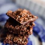 three chocolate superfood bars stacked up on a white and blue antique plate