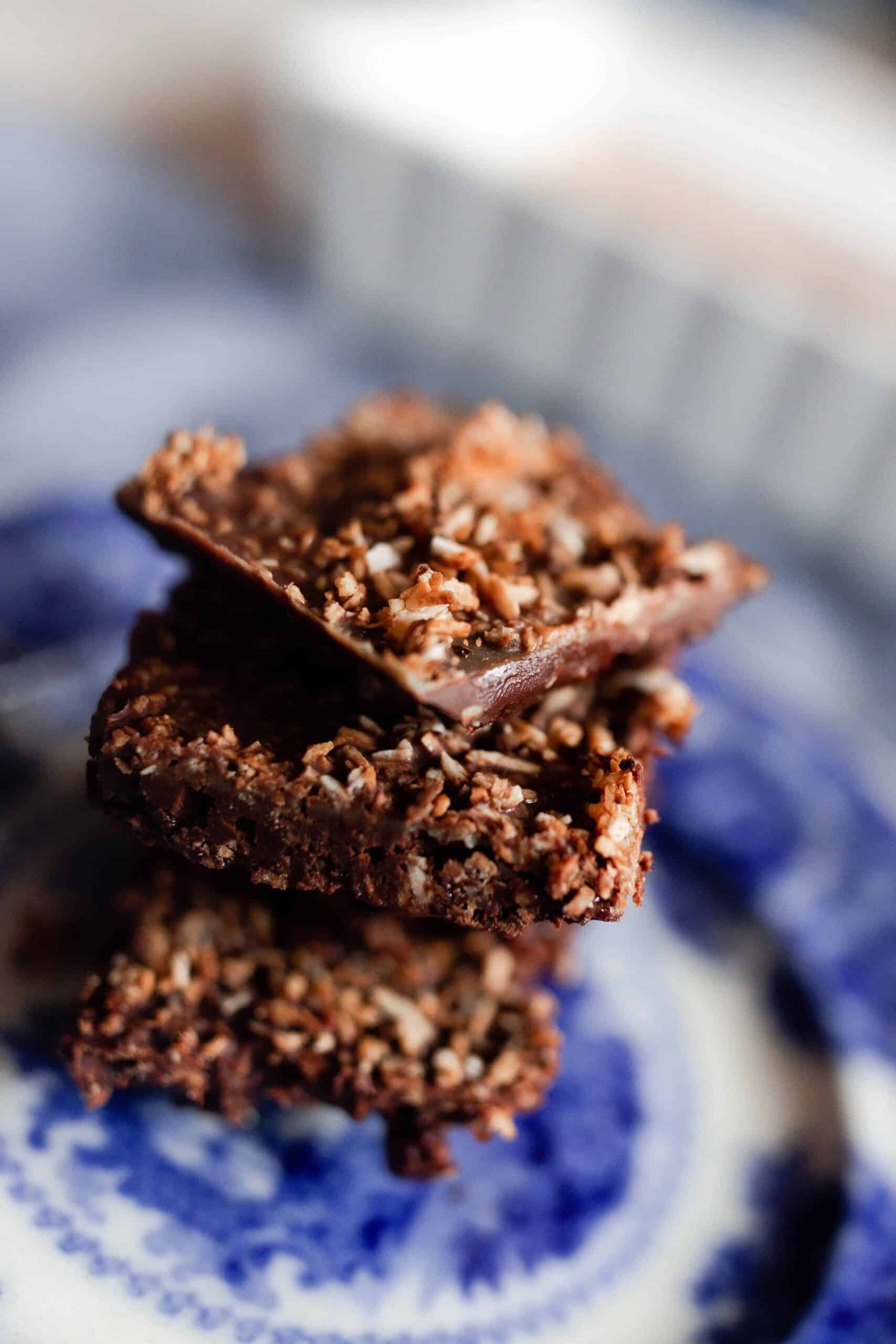 three chocolate superfood bars stacked up on a white and blue antique plate