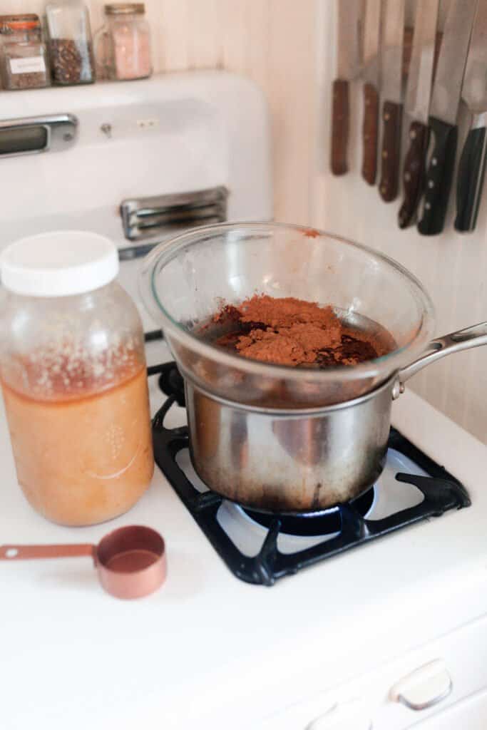 a double boiler with cocoa bliss, coconut oil, and cocoa butter