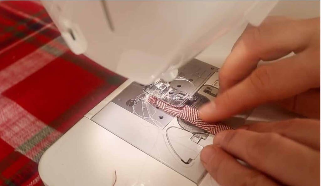 hand sewing a loop through a sewing machine