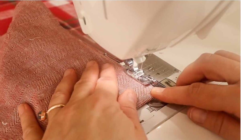women top stitching around a DIY pot holder with a sewing machine