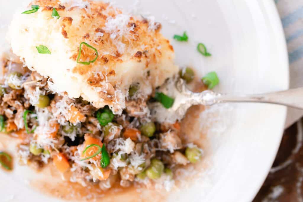 Shepards pie on a plate with an antique spoon