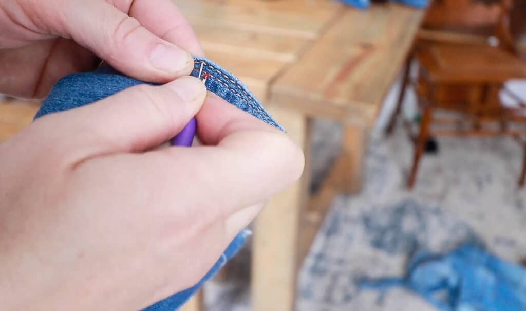 using a seam ripper to rip open seams on jeans