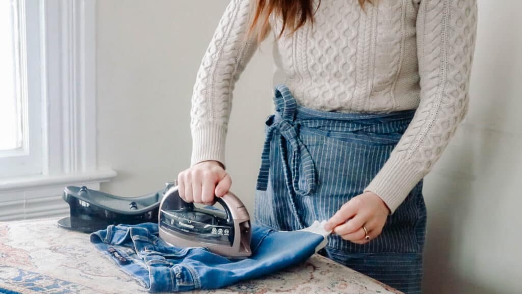 women pressing a jean skirt made from jeans on a table top