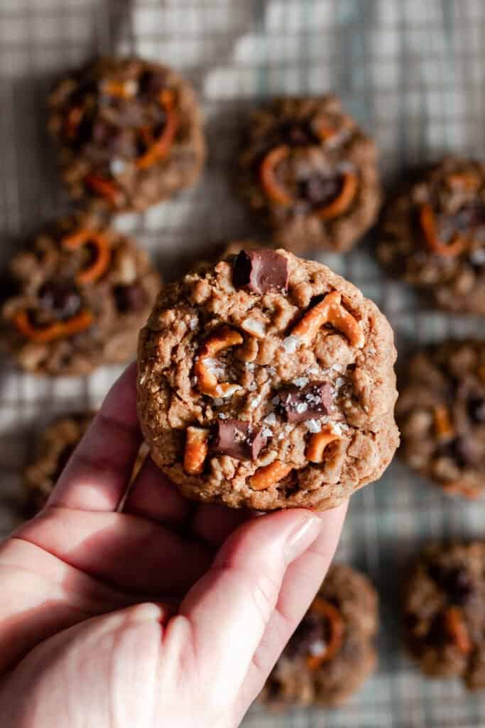 hand holding a lactation cookie with chocolate chunks, pretzels, and sea salt