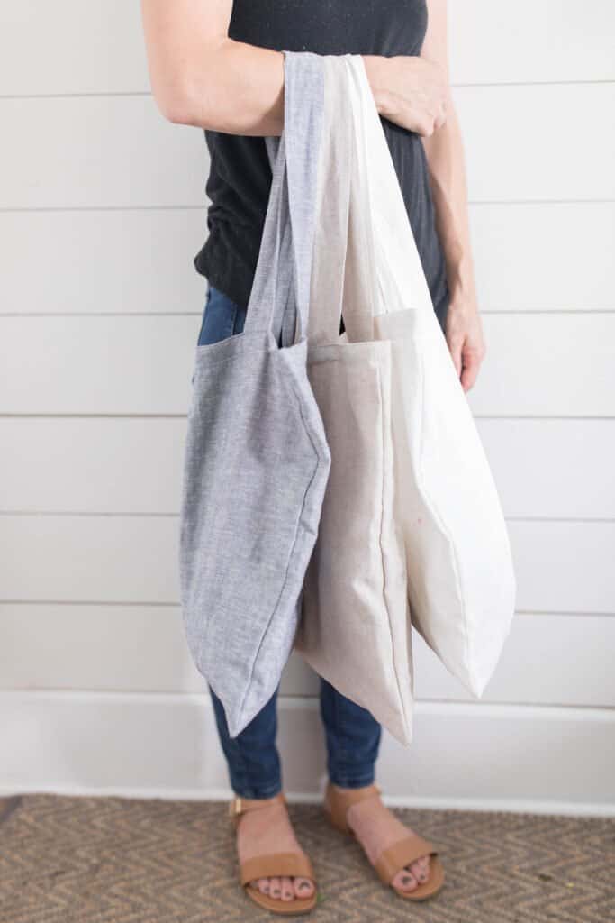 women holding three linen bags on one arm