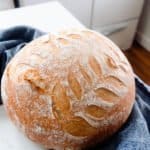 no known sourdough bread on a white countertop with a blue towel