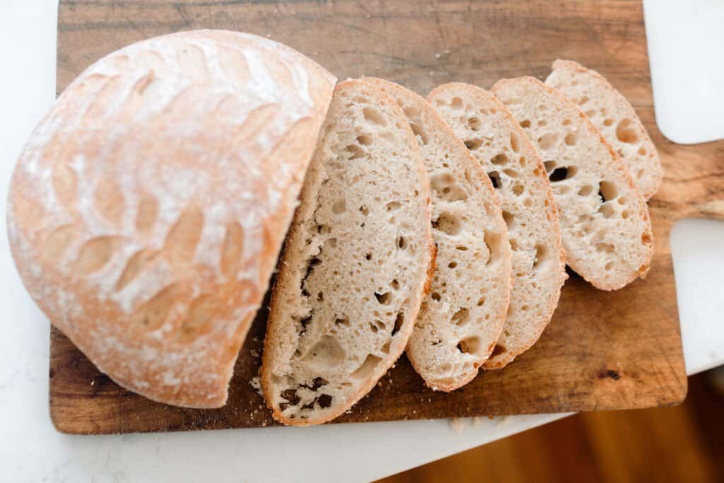 no-knead bread sliced on a large wood cutting board