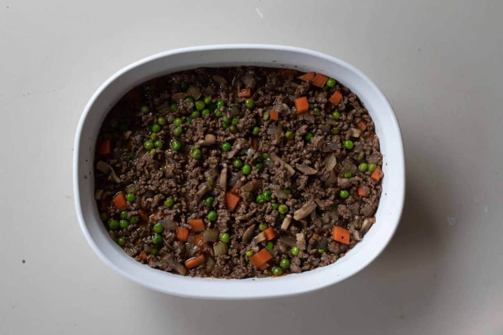 Shepherd pie filling in the bottom of a baking dish