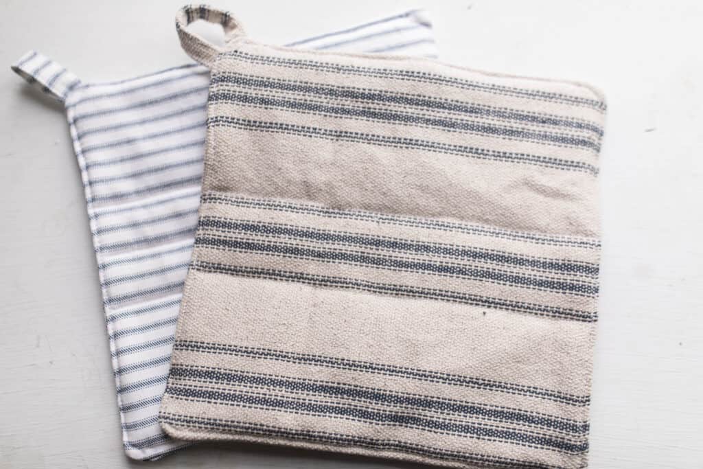 two DIY pot holders made with blue ticking stripe fabric